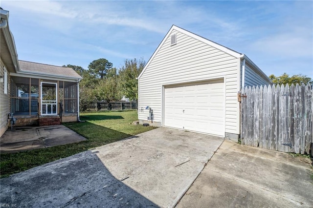 detached garage featuring driveway and fence