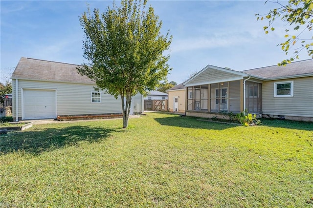 view of yard featuring an attached garage, fence, and a sunroom