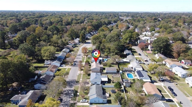 birds eye view of property featuring a residential view and a wooded view