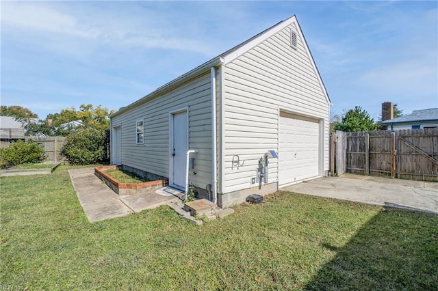 detached garage featuring a gate, fence, and concrete driveway