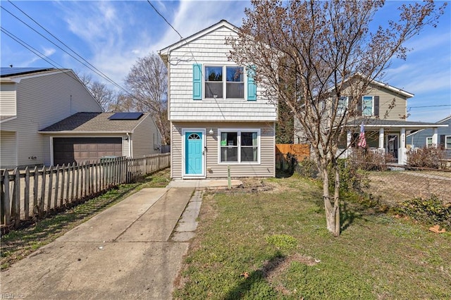 view of front of home featuring a garage, fence private yard, and a front lawn