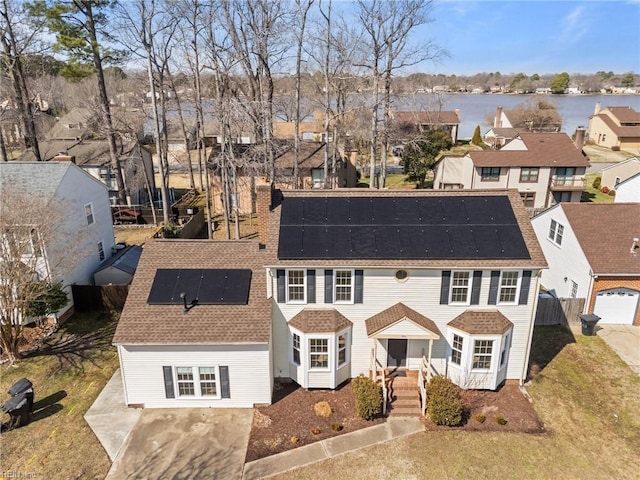 view of front of property featuring a shingled roof, a residential view, a water view, and fence