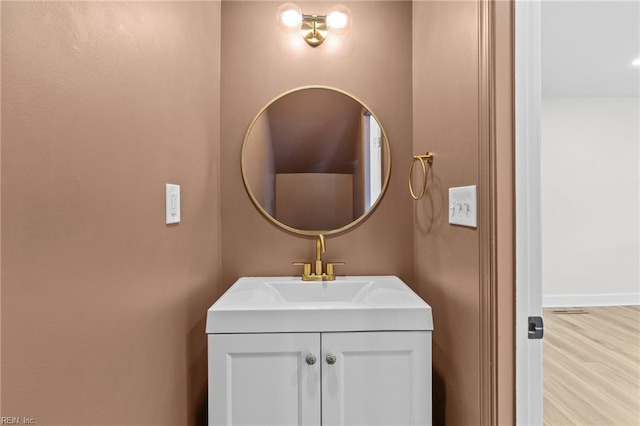 bathroom with wood finished floors, vanity, and baseboards