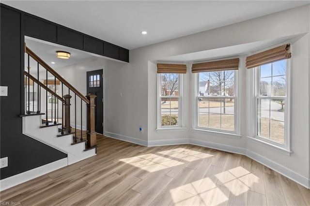 foyer with light wood finished floors, stairway, recessed lighting, and baseboards