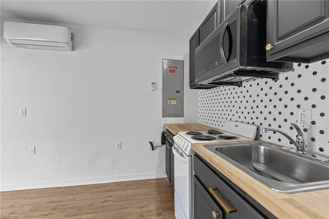 kitchen featuring electric panel, electric stove, butcher block counters, a wall mounted air conditioner, and a sink