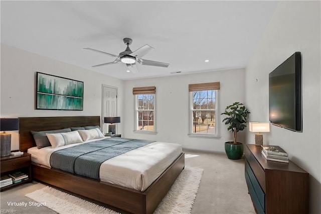 bedroom featuring light carpet, visible vents, and a ceiling fan