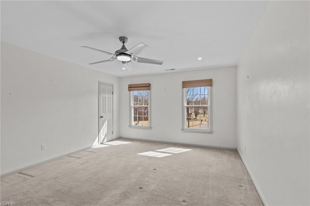 spare room with ceiling fan, carpet, visible vents, and baseboards