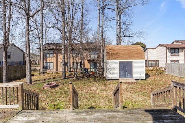 rear view of property featuring an outbuilding, a wooden deck, and a shed