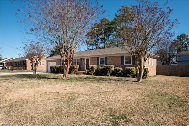 ranch-style house featuring an attached garage, fence, a front lawn, and brick siding