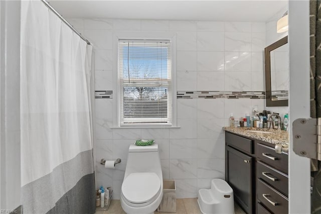 full bath with a shower with curtain, tile walls, toilet, and vanity