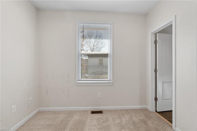 carpeted empty room with visible vents and baseboards