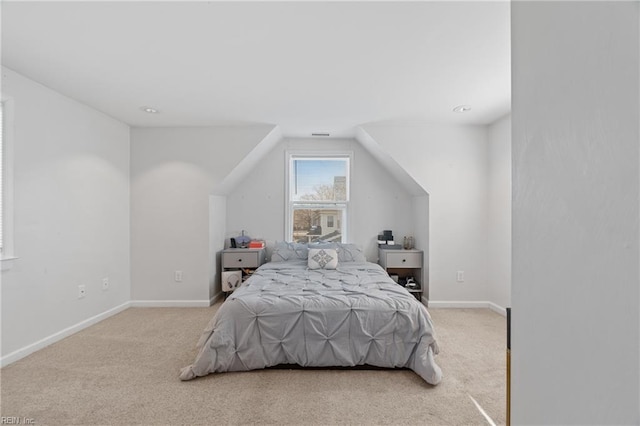 carpeted bedroom with vaulted ceiling and baseboards