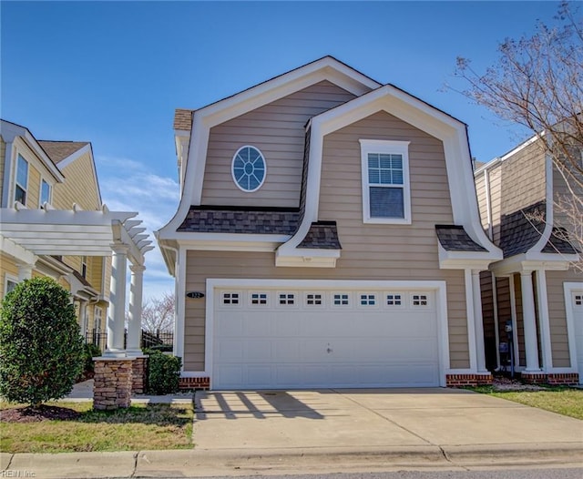 view of front of property featuring driveway, a gambrel roof, roof with shingles, an attached garage, and a pergola