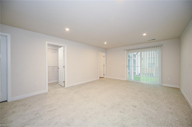 carpeted spare room featuring recessed lighting, visible vents, and baseboards