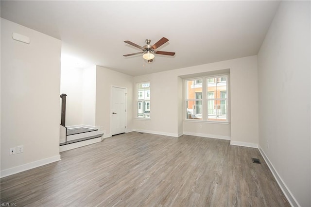 unfurnished room featuring visible vents, baseboards, and wood finished floors