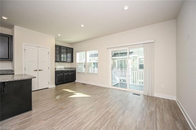 interior space featuring light wood finished floors, baseboards, and visible vents