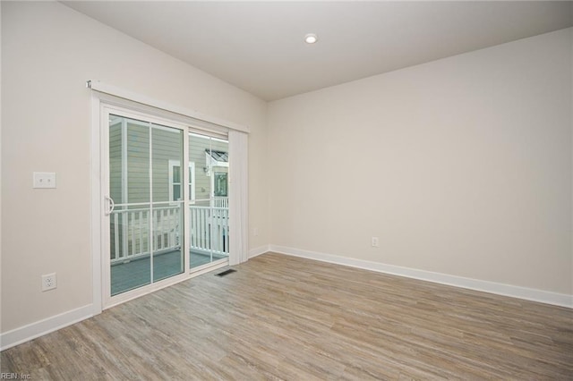 empty room featuring recessed lighting, wood finished floors, and baseboards