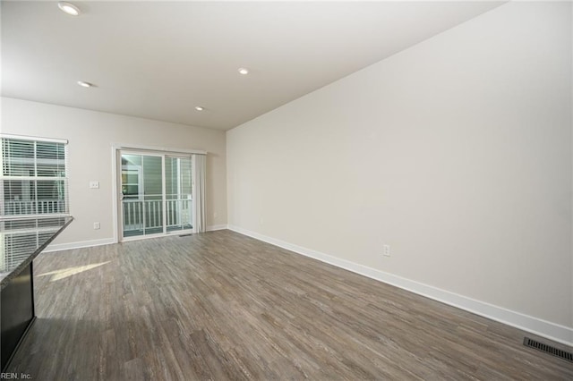 spare room featuring dark wood-style floors, recessed lighting, visible vents, and baseboards