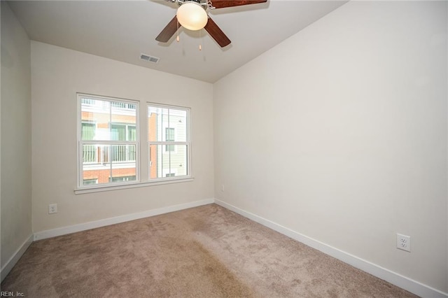 spare room with a ceiling fan, baseboards, visible vents, and carpet flooring