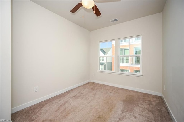 unfurnished room featuring carpet floors, baseboards, visible vents, and ceiling fan