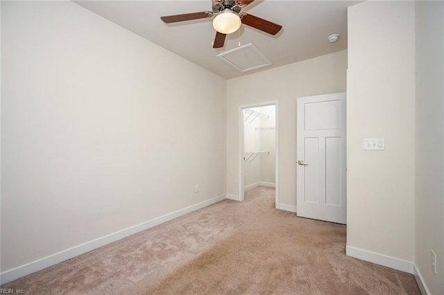 empty room with attic access, light carpet, and baseboards