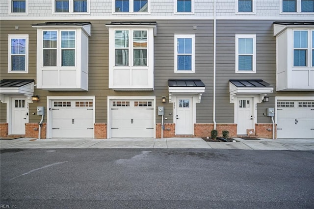 view of property featuring a garage and brick siding