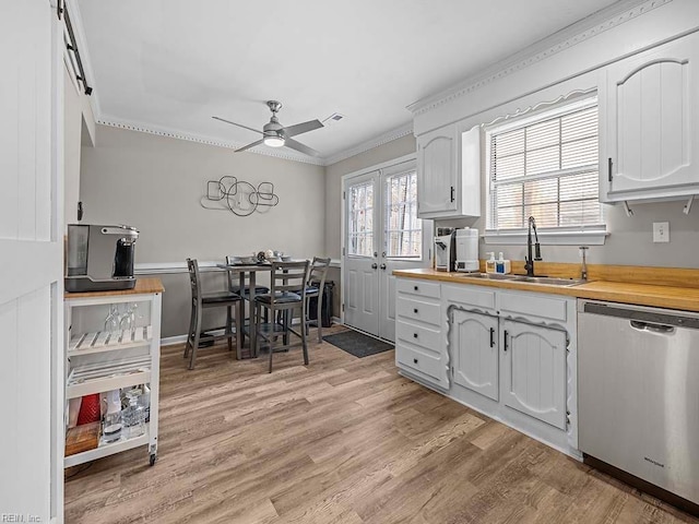 kitchen featuring a sink, wood counters, light wood-style floors, stainless steel dishwasher, and crown molding