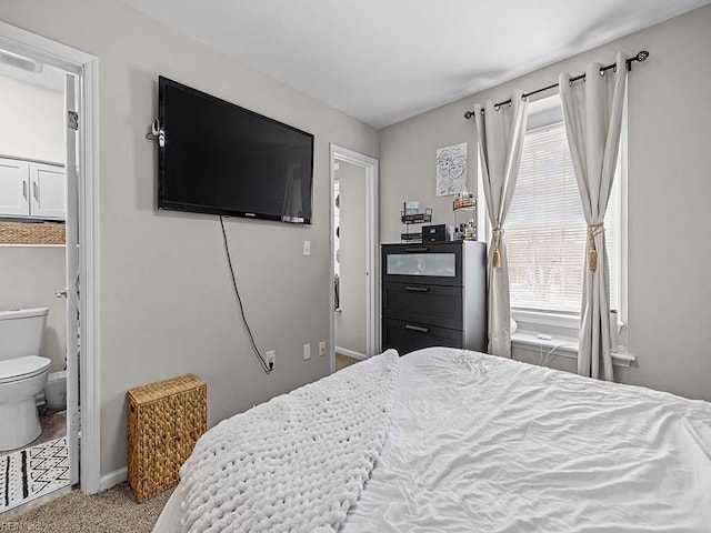 bedroom with carpet floors, connected bathroom, and baseboards