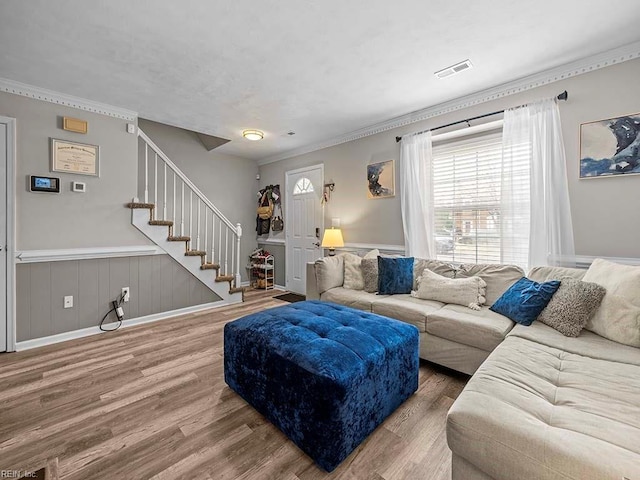 living room featuring visible vents, crown molding, stairway, and wood finished floors