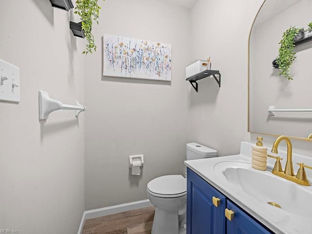 bathroom featuring vanity, wood finished floors, toilet, and baseboards