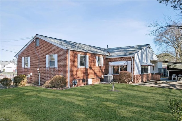 back of property with fence, a lawn, central AC, and brick siding