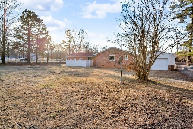 exterior space featuring brick siding, fence, and an outdoor structure