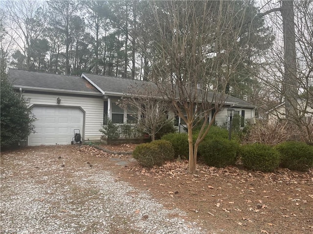 ranch-style home with a garage and dirt driveway