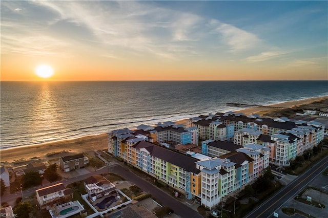 aerial view at dusk featuring a water view