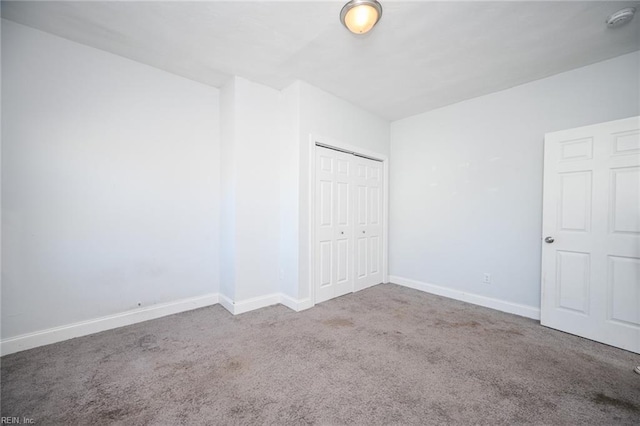 unfurnished bedroom featuring carpet, a closet, and baseboards