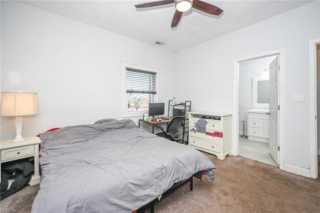 carpeted bedroom with baseboards, ensuite bath, visible vents, and a ceiling fan