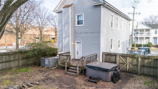 back of property featuring a fenced backyard, central AC, and a wooden deck