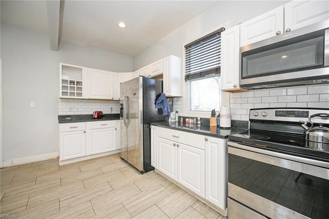 kitchen featuring dark countertops, white cabinetry, appliances with stainless steel finishes, and wood finish floors