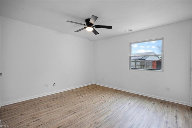 unfurnished room with ceiling fan, wood finished floors, visible vents, and baseboards