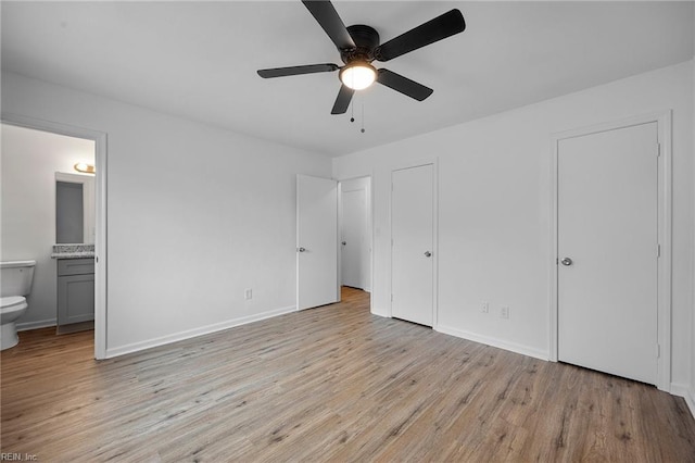 unfurnished bedroom featuring ensuite bathroom, ceiling fan, light wood-type flooring, and baseboards