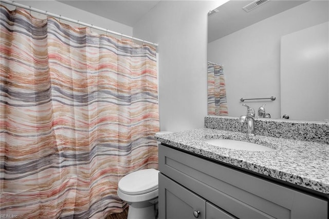 bathroom with toilet, visible vents, and vanity