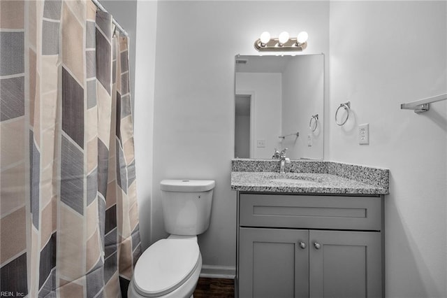 full bathroom featuring a shower with shower curtain, baseboards, vanity, and toilet