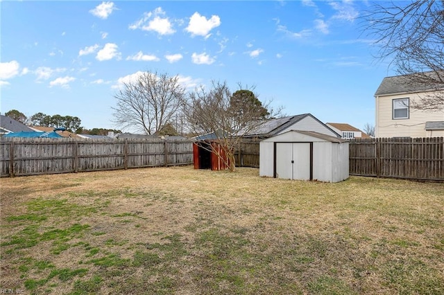 view of yard with an outbuilding, a fenced backyard, and a storage shed