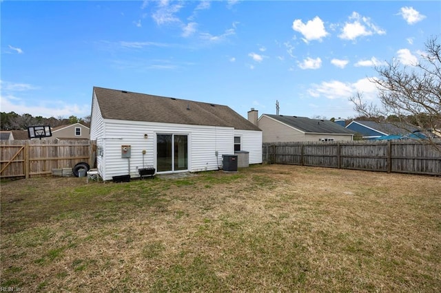 back of house featuring a lawn, cooling unit, and a fenced backyard