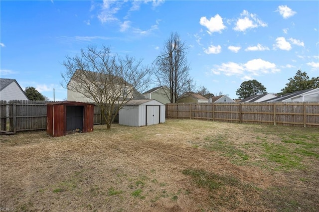 view of yard with an outbuilding, a fenced backyard, and a storage unit