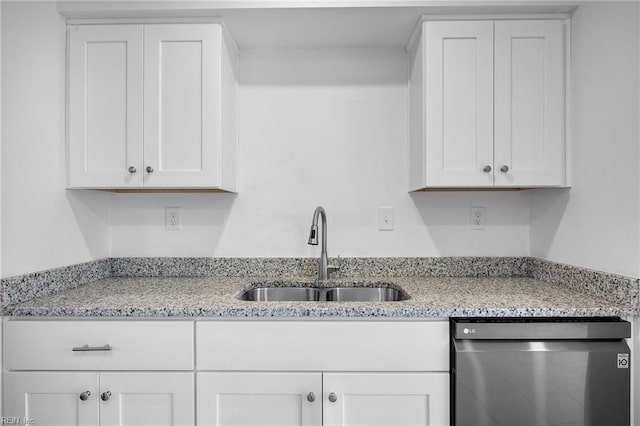 kitchen with stainless steel dishwasher, a sink, light stone countertops, and white cabinets