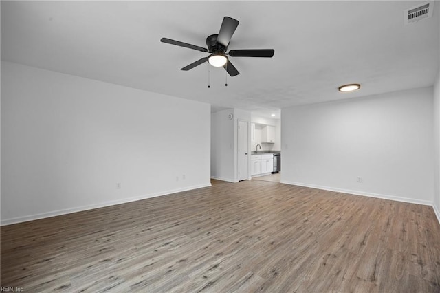 unfurnished living room with light wood finished floors, baseboards, visible vents, and ceiling fan