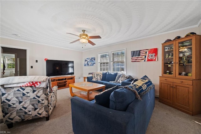 living room featuring carpet floors, ornamental molding, and a ceiling fan