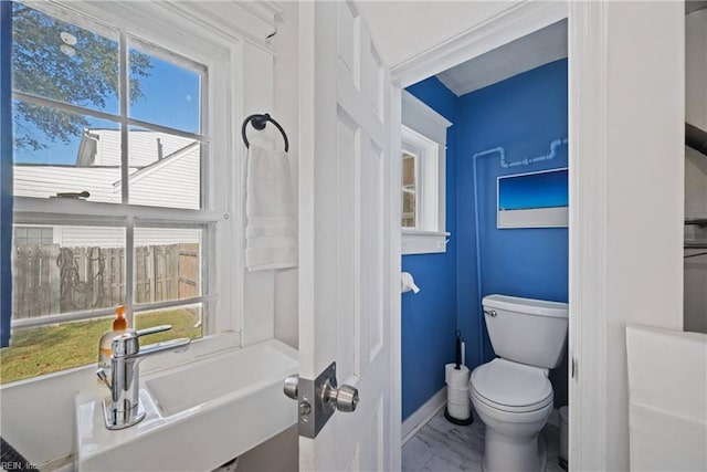 bathroom with baseboards, a sink, and toilet