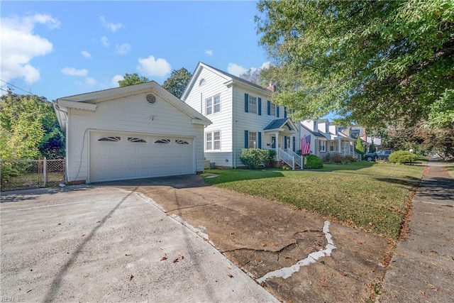 view of front facade with a garage, concrete driveway, a front yard, and fence